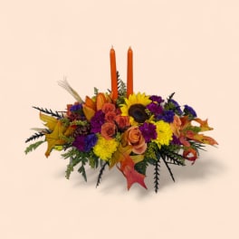 Autumn floral centerpiece with orange candles and mixed blooms