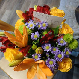 Colorful bouquet with yellow roses, orange lilies, and purple daisies