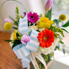 Colorful bouquet with gerbera daisies, tulips, and striped ribbon