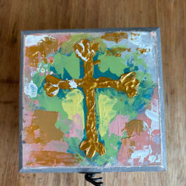Abstract painted square box with a gold cross on a colorful background