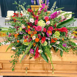 Large colorful floral casket spray with roses and tropical blooms