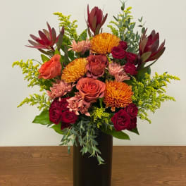 Mixed bouquet of roses and chrysanthemums in a black vase