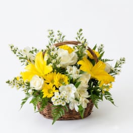 Yellow and white flowers arranged in a wicker basket