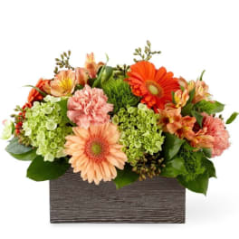 Mixed bouquet in a rectangular wooden box with orange and peach blooms