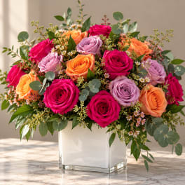 Mixed rose arrangement in a white square vase