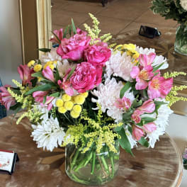 Pink roses and white daisies arranged in a clear glass vase