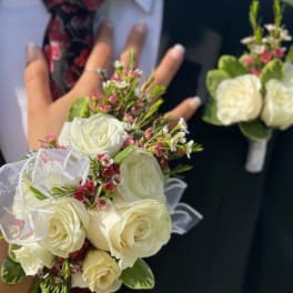White rose bouquet and matching boutonniere on a suit jacket