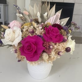 Bouquet of hot pink and white roses in a white vase