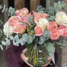 Bouquet of pink and white roses in a clear glass vase