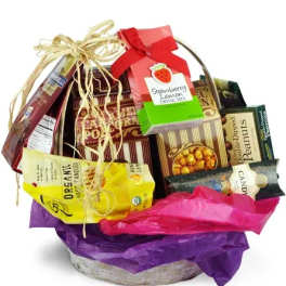 Basket of assorted candy and snack boxes with colorful tissue paper