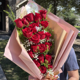 Bouquet of red roses wrapped in pink paper