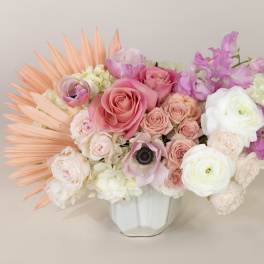 Pink and white floral arrangement in a white vase with peach accents