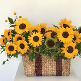 Basket of bright yellow sunflowers with dark centers