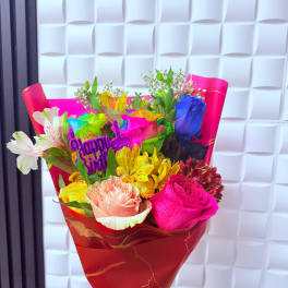 Bright mixed bouquet with roses and alstroemeria in red wrapping