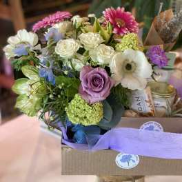 Mixed bouquet with roses, anemones, and daisies in a gift box