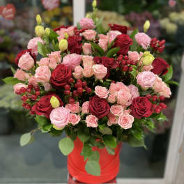Bouquet of red and pink roses in a red hat box