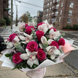Bouquet of hot pink roses and white orchids wrapped in pale paper