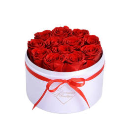 Red roses arranged in a white round box with a red ribbon
