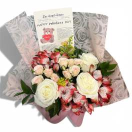 Bouquet of white roses and pink alstroemeria with a Valentine card