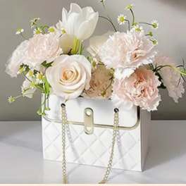 White and blush flowers arranged in a white handbag-style box