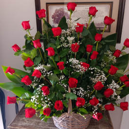 Basket arrangement of red roses and baby's breath