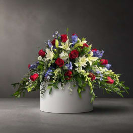 Red roses and white lilies arranged in a white round container