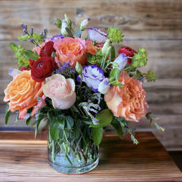 Mixed bouquet of roses and lisianthus in a clear glass vase