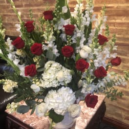 Red roses and white flowers arranged in a large vase