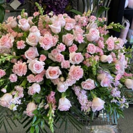 Large pink rose and carnation floral spray with greenery