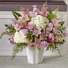 Pink and white floral arrangement in a white vase