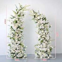 Tall asymmetrical white floral pillars forming an open wedding arch.