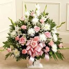 Pink and white floral spray with a pink ribbon on a stand