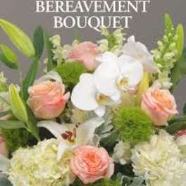 Mixed bouquet with white orchids, peach roses, and pale blooms