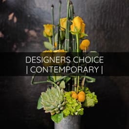 Yellow roses and succulents in a tall vase arrangement