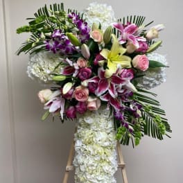 Large floral standing spray with lilies, roses, orchids, and white hydrangeas