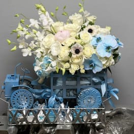 Blue and white floral arrangement in a decorative metal cart