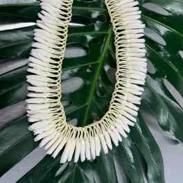 White floral lei on a large green leaf