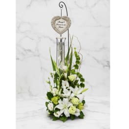White floral sympathy arrangement with a heart memorial ornament
