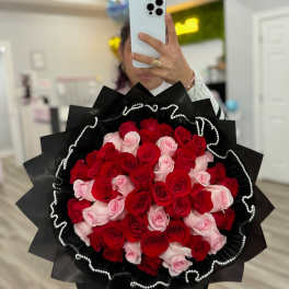 Large bouquet of red and pink roses wrapped in black paper