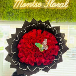 Red rose bouquet wrapped in black paper with a butterfly accent