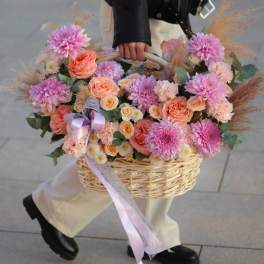 Basket of pink and peach flowers with a lavender ribbon