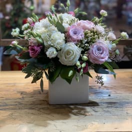 Bouquet of pink and white roses in a white square vase