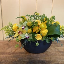 Yellow floral arrangement in a black bowl vase