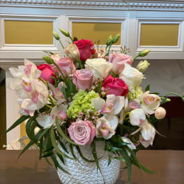 Pink and white roses with orchids in a textured white vase