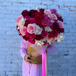Large bouquet of red, pink, and white roses in a gold box