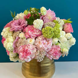 Pink and white floral arrangement in a gold vase