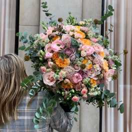 Large bouquet of pink, peach, and lavender roses with eucalyptus