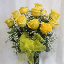 Yellow roses in a clear glass vase with a yellow ribbon