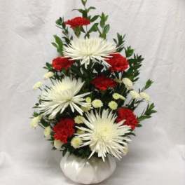White spider mums and red carnations in a white vase