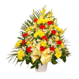 Yellow and red floral arrangement in a white vase with a ribbon
